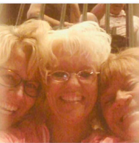Three women with blonde hair smiling together in a group selfie.